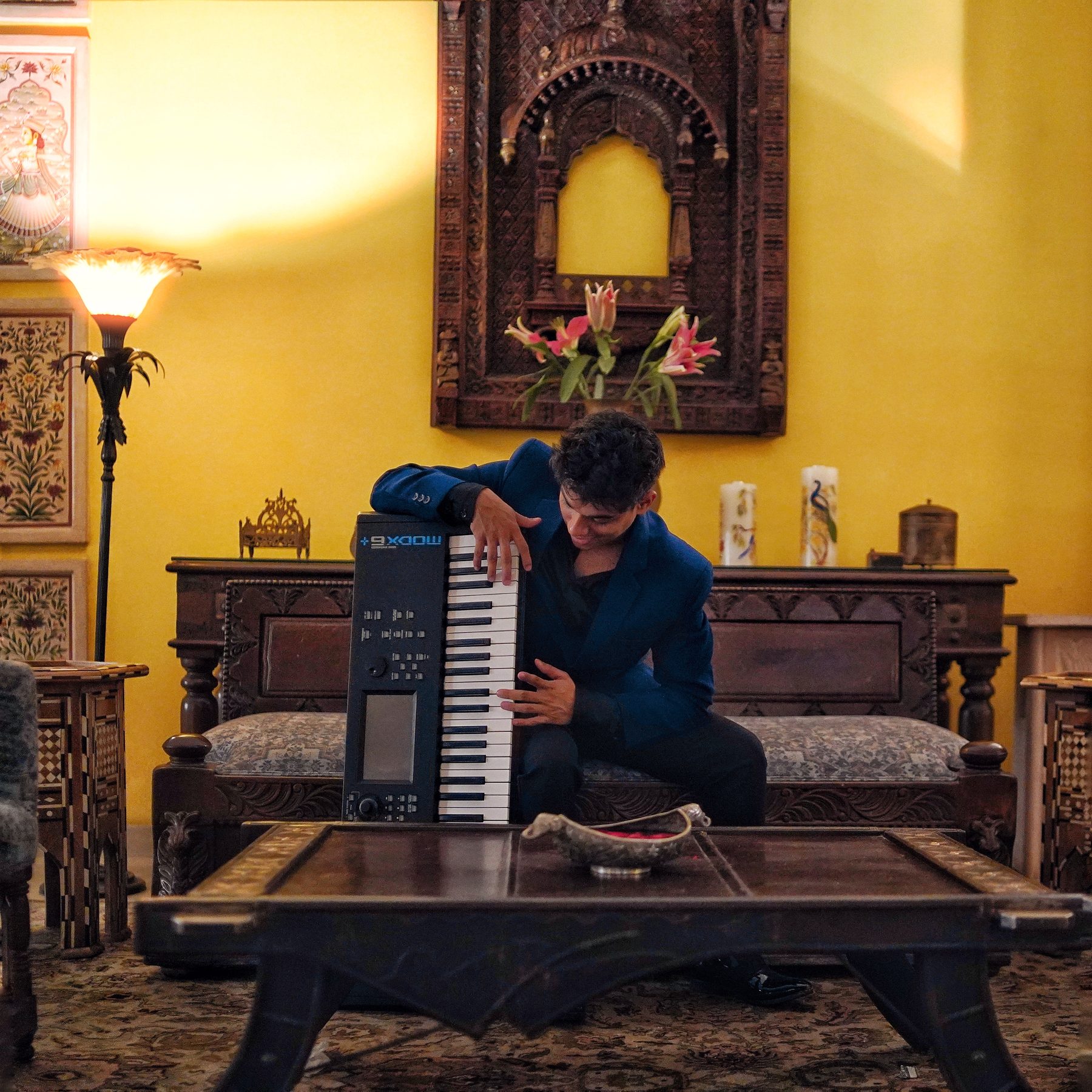 Kenn seated with a Yamaha MODX6+ keyboard in a sunlit room